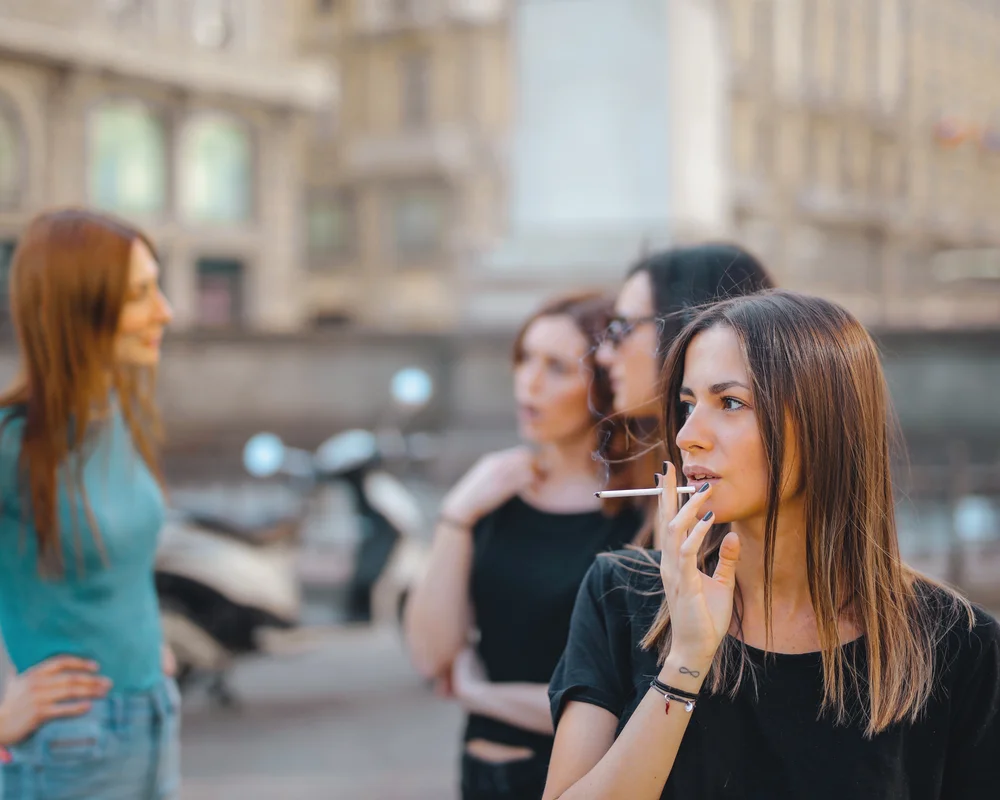 Ragazza fuma una sigaretta con le amiche